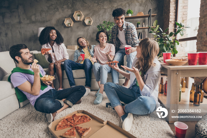 Portrait of attractive cheerful friends having fun eating junk snack communicating gathering in hous