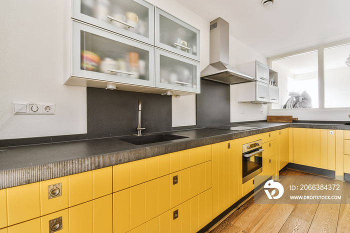 Pretty kitchen with yellow kitchen unit and hanging cabinets with frosted glass