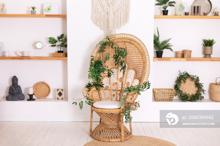 Design peacock wicker chair and wooden shelfs with decor in stylish bedroom interior. Rattan peacock