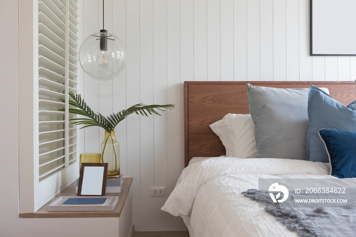 modern cozy white bedroom with side table lamp