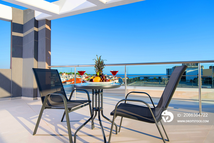 Recreation concept panorama of modern patio with fruits, wine, table, chairs on roof top terrace of 