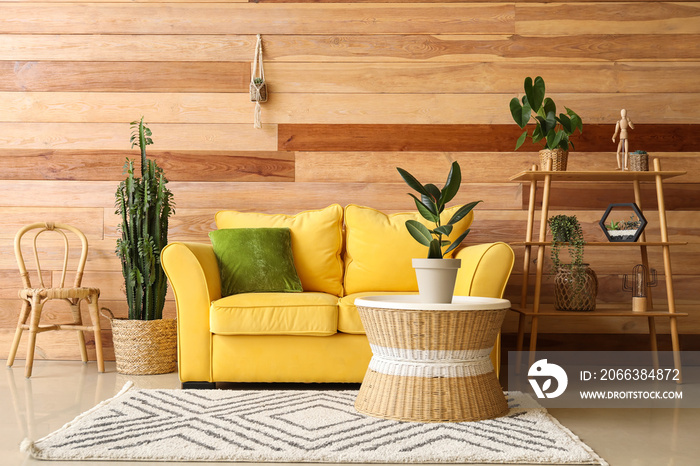 Interior of modern living room with houseplants and wooden wall