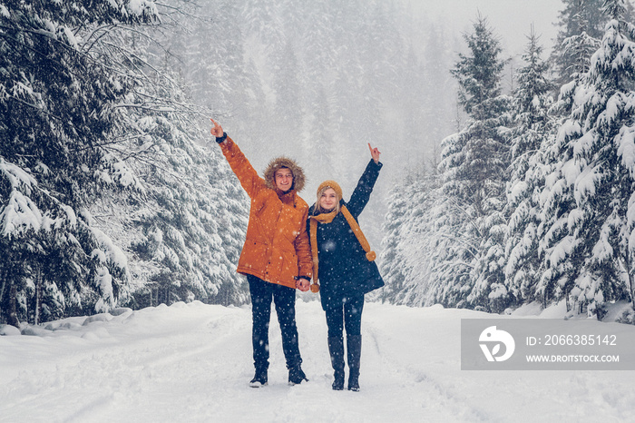 Guy and girl walk and have fun in the forest in winter