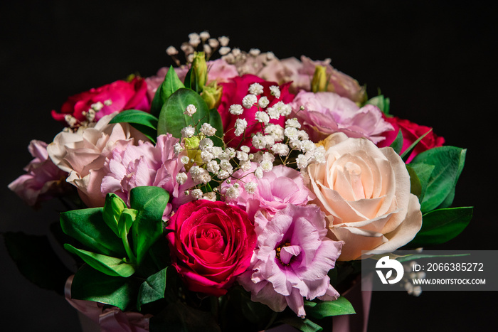 Beautiful bouquet of colorful rose flowers on a black background. Festive flowers concept with copy 