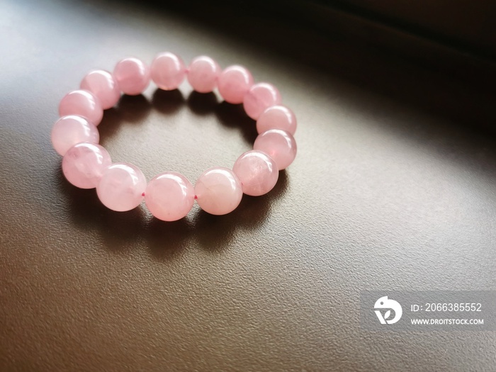 Rose quartz bracelet with copy space on the right side.   Selective focus.