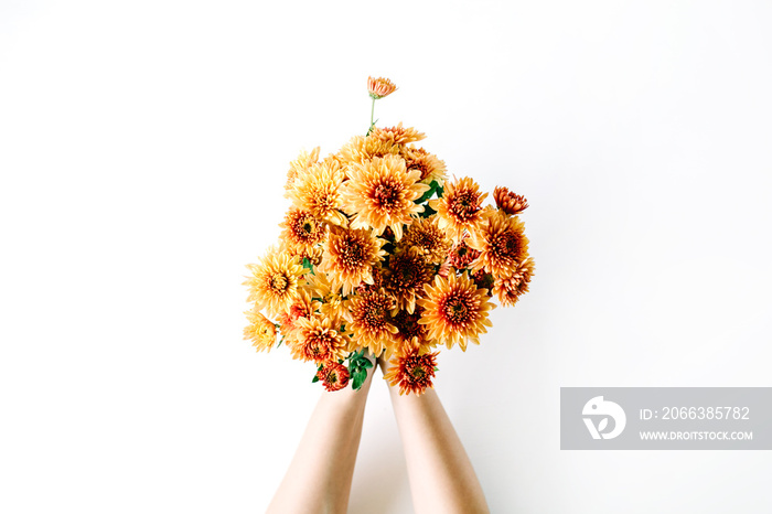 chrysanthemum bouquet in girls hands on white background. flat lay, top view concept
