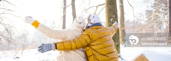 happy loving couple in snowy winter forest