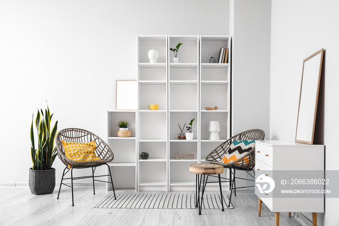 Interior of light room with big shelving unit and wicker armchairs