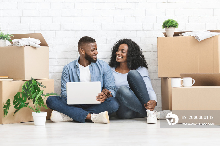 Smiling man and woman purchasing furniture online for new apartment