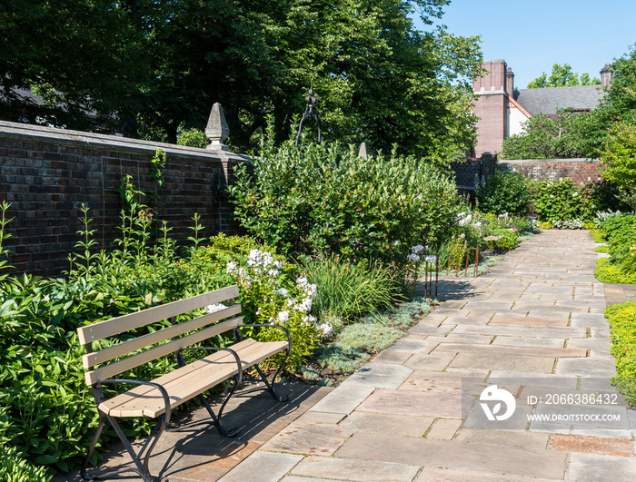 Two wooden benches in a flower garden in city owned Mellon Park in Pittsburgh, Pennsylvania, USA on 