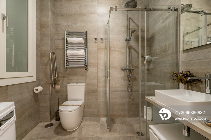 Bathroom with faux marble tile, walk in shower with sliding glass doors, frameless mirror on the wal