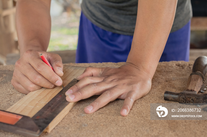 craftsman using the pencil marking make on the wooden product working at carpentry workshop  furnitu