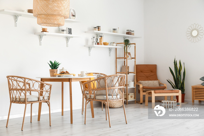 Interior of light dining room with wicker chairs and table