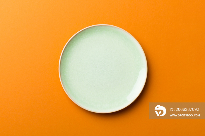 Top view of isolated of colored background empty round green plate for food. Empty dish with space f