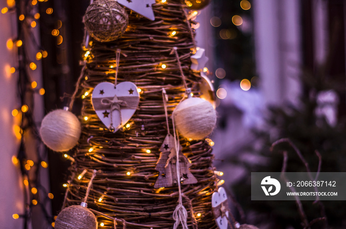 Christmas tree from wooden branches with ornaments and garlands