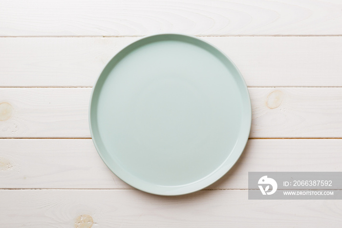 Top view of empty blue plate on wooden background. Empty space for your design