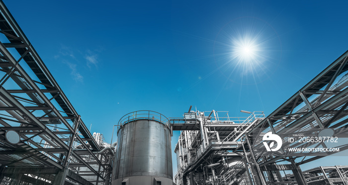 Manufacturing of chemical industrial plant with pipeline and stainless tank on blue sky background