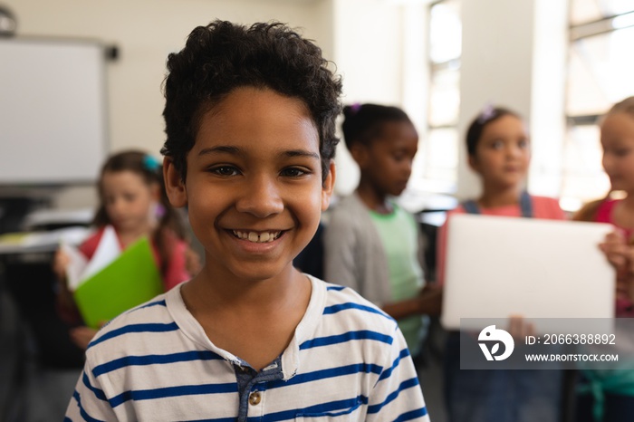 Happy schoolboy looking at camera in classroom of elementary