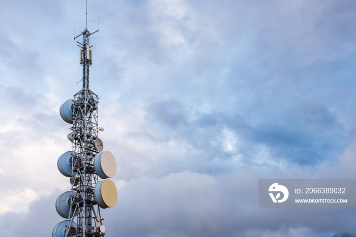 Telecommunication, television and radio antennas isolated over dramatic sky with clouds. industry an