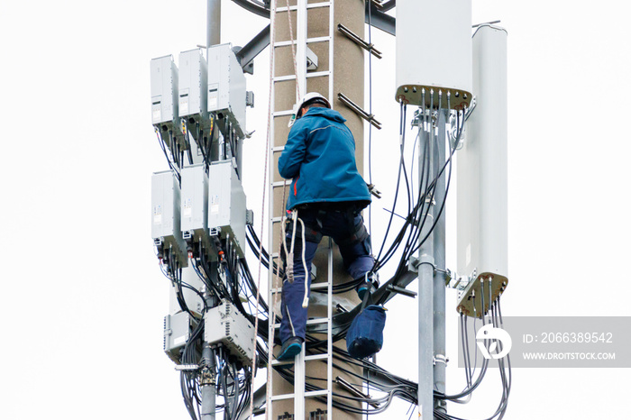 2 technicians carry out repairs on a radio mast