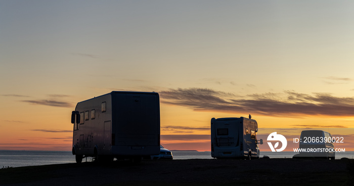 Campervans Silhouettes Against Colourful Sky