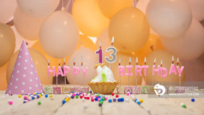 Beautiful background happy birthday number 13 with burning candles, birthday candles pink letters for a thirteen year old child. Festive background with balloons