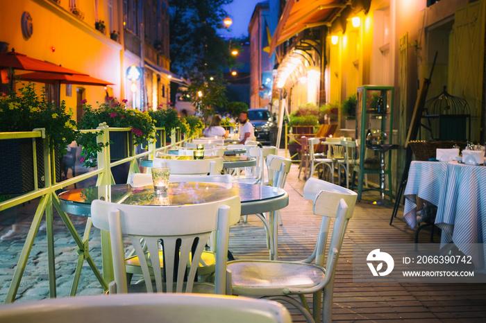 Outdor restaurant terrace at night old European city street.