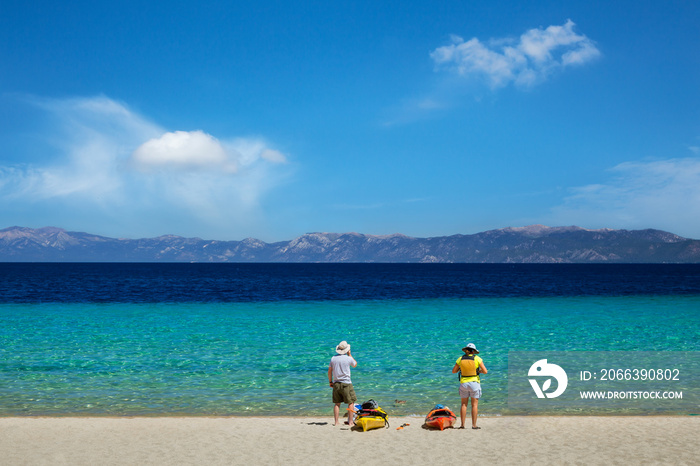 Two kayak enthusiasts getting ready to go kayaking on the turquoise waters of Lake Tahoe