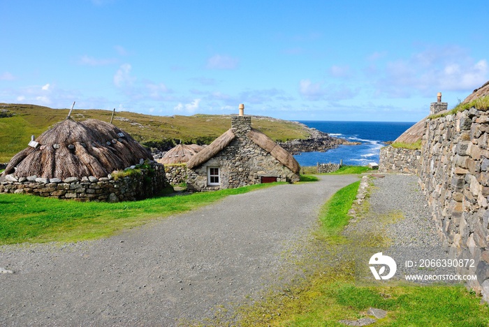 Garenin blackhouse village on the west coast of the Isle of Lewis in the Outer Hebrides of Scotland, UK on a beautiful sunny day with a view of a Garenin bay