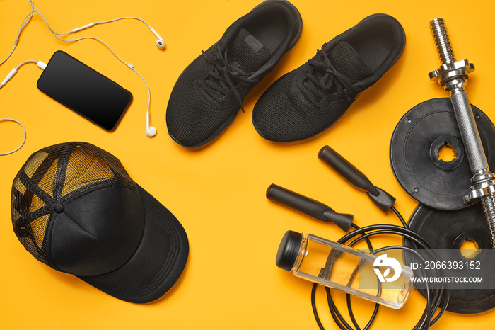 Close-up studio shot of a gym accessories on a yellow background. Top view, flat lay.