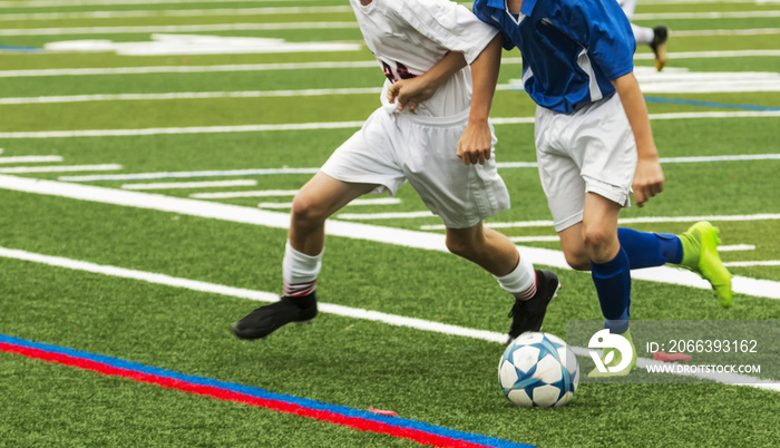 Two boys fight for soccer ball in game