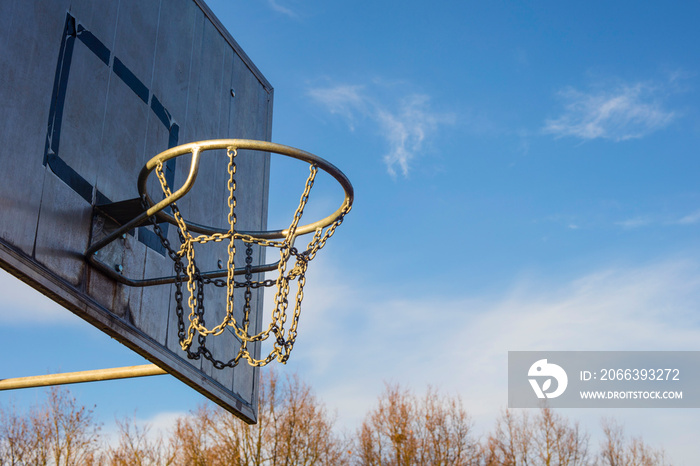 Detail of golden basketball basket outdoors in sunset blue sky