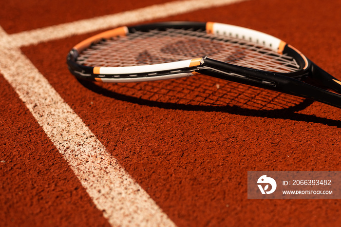 Broken tennis racket on clay tennis court