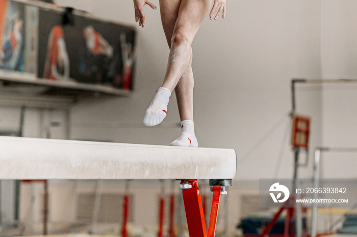 girl gymnast athlete exercise on balance beam in gymnastics gym