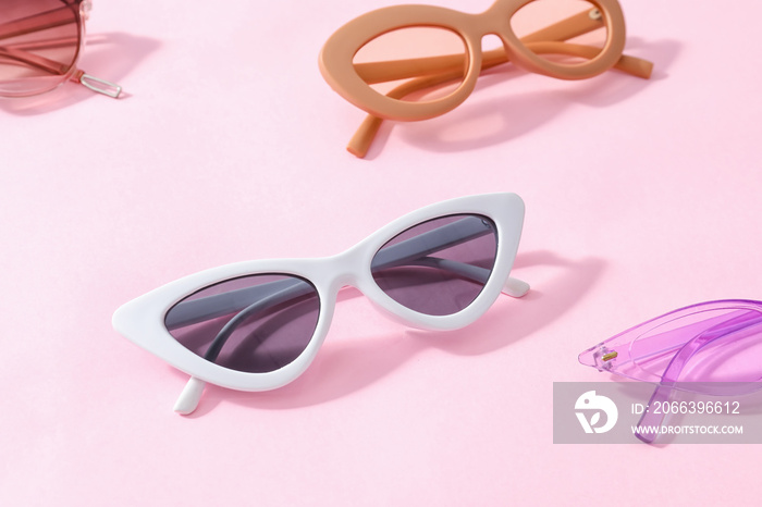 Stylish sunglasses on color background