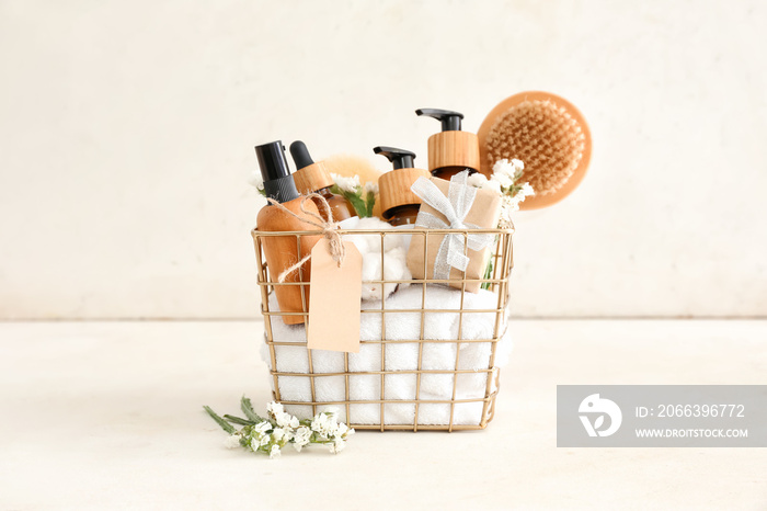 Gift basket with cosmetic products on light background