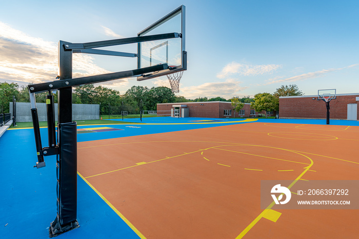 Late afternoon photo of a new outdoor blue and orange basketball court