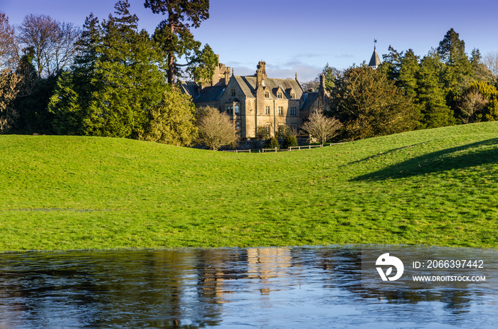 An English mansion with frozen water in the foreground.