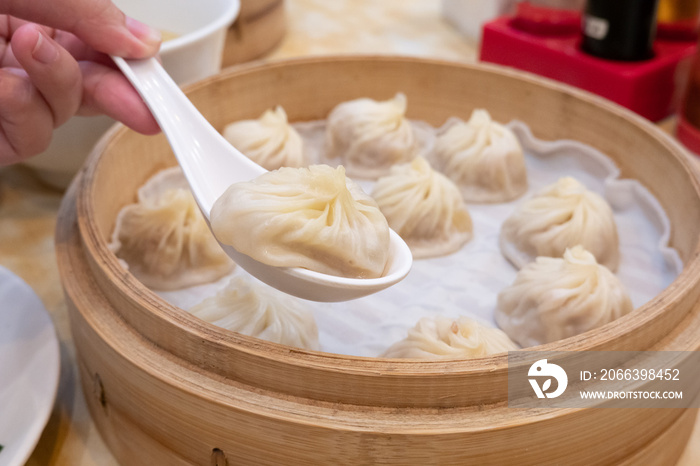 Xiao long bao soup dumpling buns with chopsticks in restaurant (Traditional Chinese food) in Taipei Taiwan