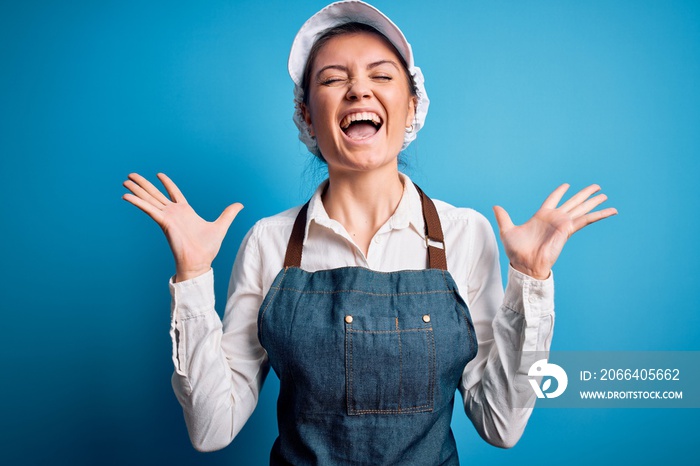 Young beautiful baker woman with blue eyes wearing apron and cap over blue background celebrating ma