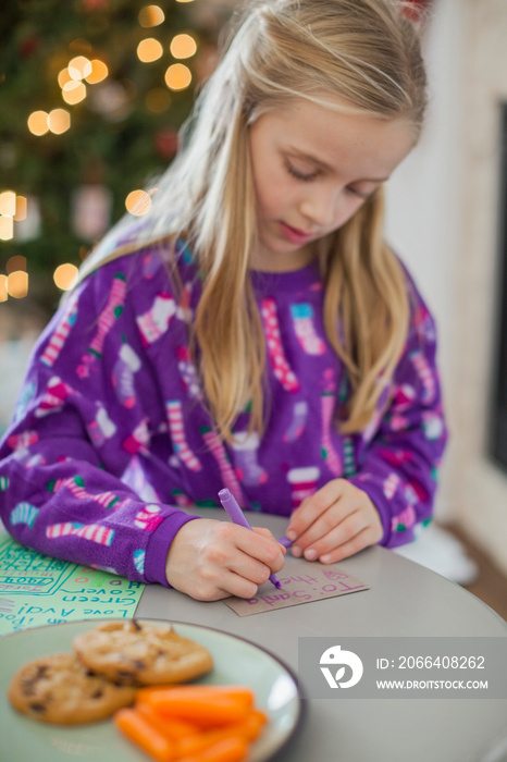 Young girl writing note to Santa