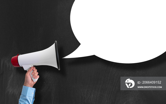 hand of businessman holding megaphone or bullhorn against blackboard with empty speech bubble