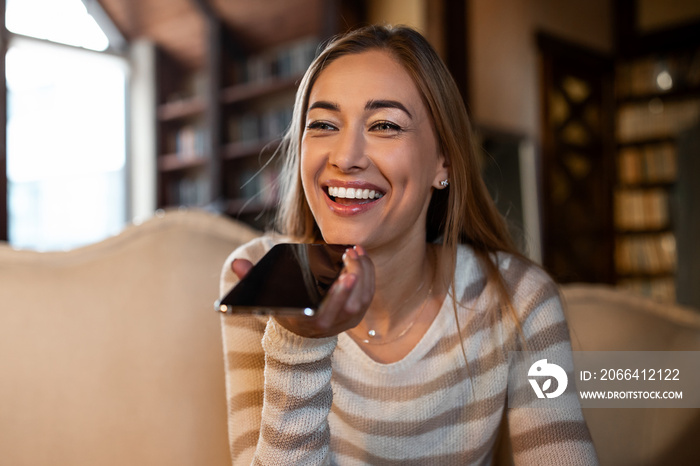 Closeup of happy woman using voice assistant on cellphone