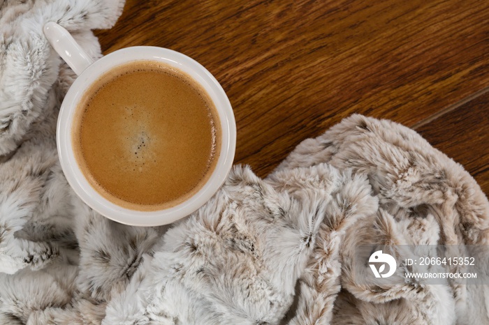 Blanket and coffee on wooden background