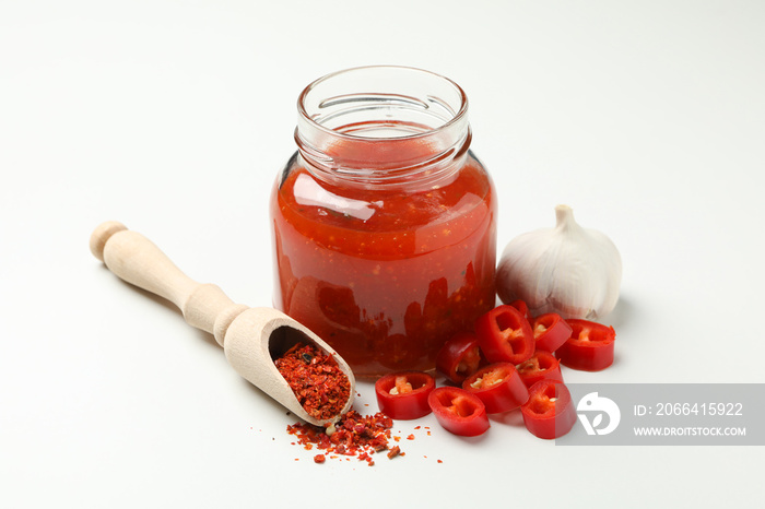 Chilli, garlic, spice and jar with sauce on white background