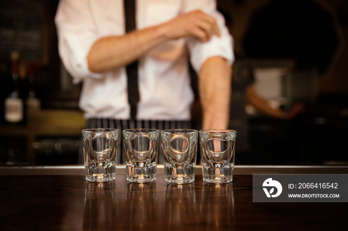 Shot glasses lined up on bar counter