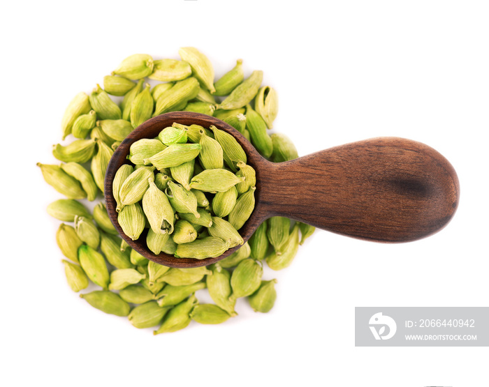 Cardamom seeds in wooden spoon, isolated on white background. Pile of green cardamom pods. Top view.