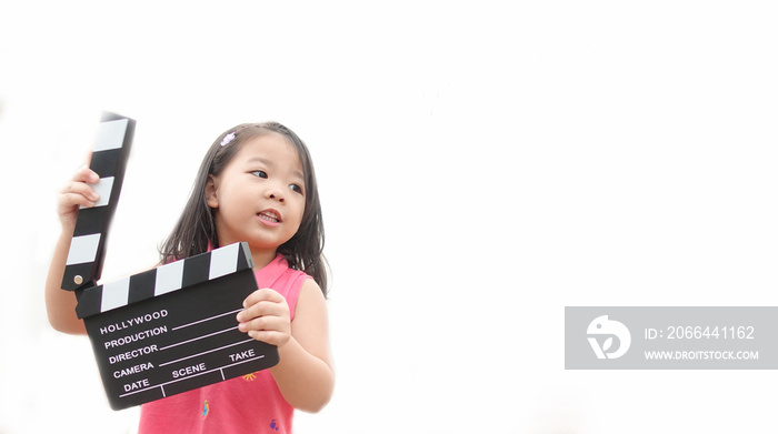 亚洲小女孩手拿拍手板在工作室制作视频电影。儿童电影制作