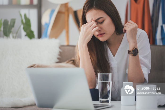 Asian beautiful women stressful and headache after working with a laptop for a long time.Hand holdin