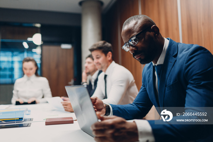 African american black man businessman sitting at table working laptop on office team people backgro